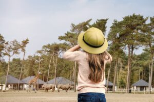 Een mooie foto meisje die over safari resort kijkt met dieren op de achtergrond