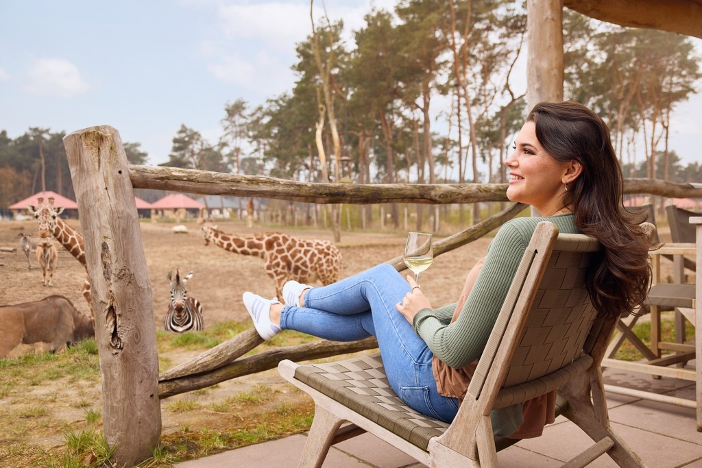 Een vrouw op terras uitkijk op wilde dieren safari resort